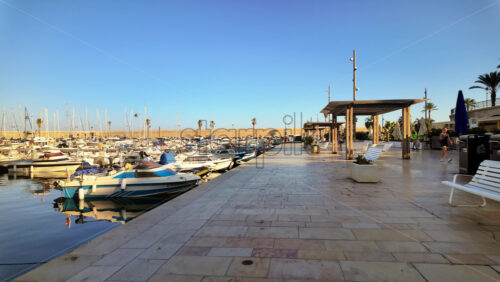 Video - Menton, France - September 4, 2024: People walking near boats docked in the Port de Menton in the French Riviera