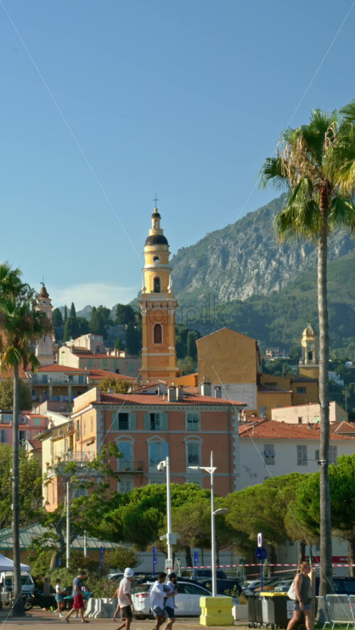 Video - Menton, France - September 4, 2024: Distant view of the St Michel Basilica surrounded by colourful buildings. Vertical