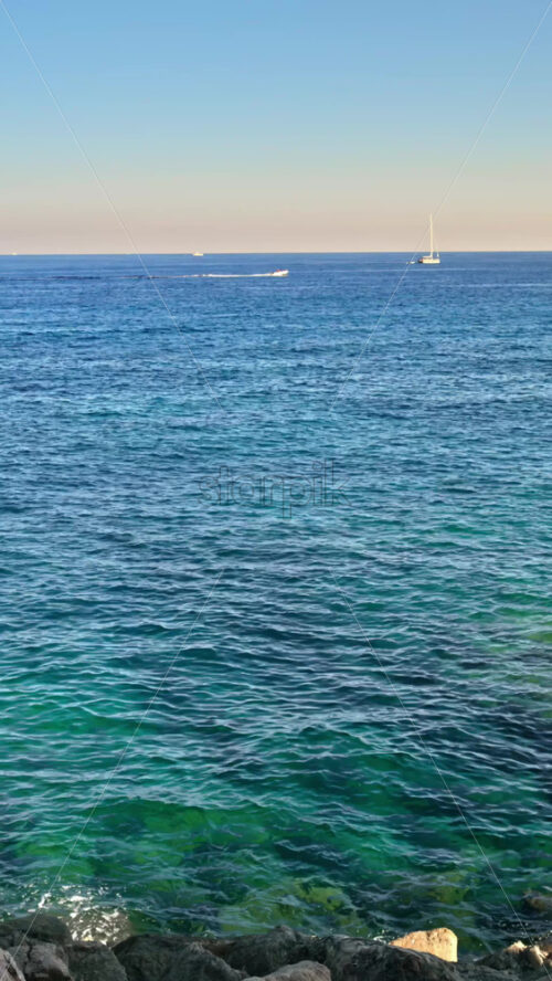 Video - Distant view of boats moving on the sea in Menton, the French Riviera. Vertical