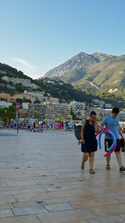Video - Menton, France - September 4, 2024: People walking on the streets near the beach. Vertical
