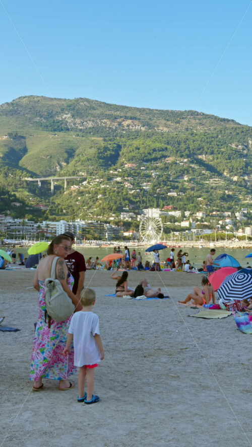 Video - Menton, France - September 4, 2024: People walking on the streets near the beach. Vertical