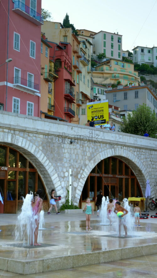 Video - Menton, France - September 4, 2024: View of the colourful buildings in the city and people walking by the coastline. Vertical
