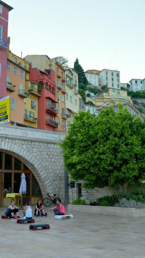Video - Menton, France - September 4, 2024: View of the colourful buildings in the city and people walking by the coastline. Vertical