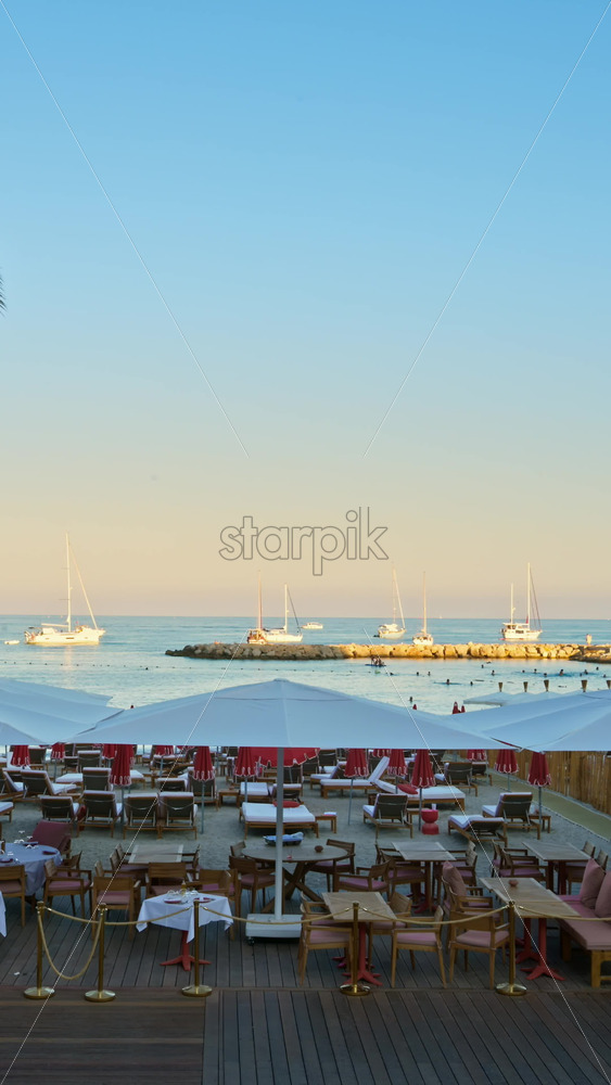 Video - Menton, France - September 4, 2024: View of a restaurant on the beach in the evening. Vertical