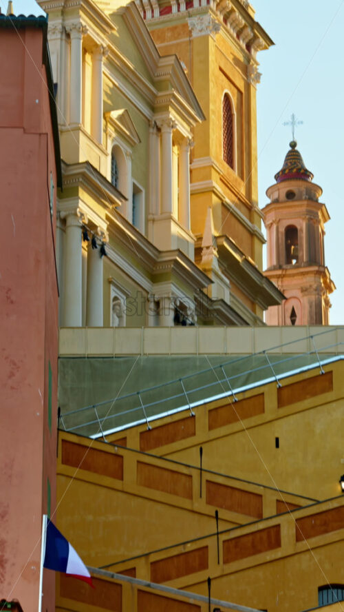 Video - Menton, France - September 4, 2024: View of the St Michel Basilica surrounded by colourful buildings. Vertical
