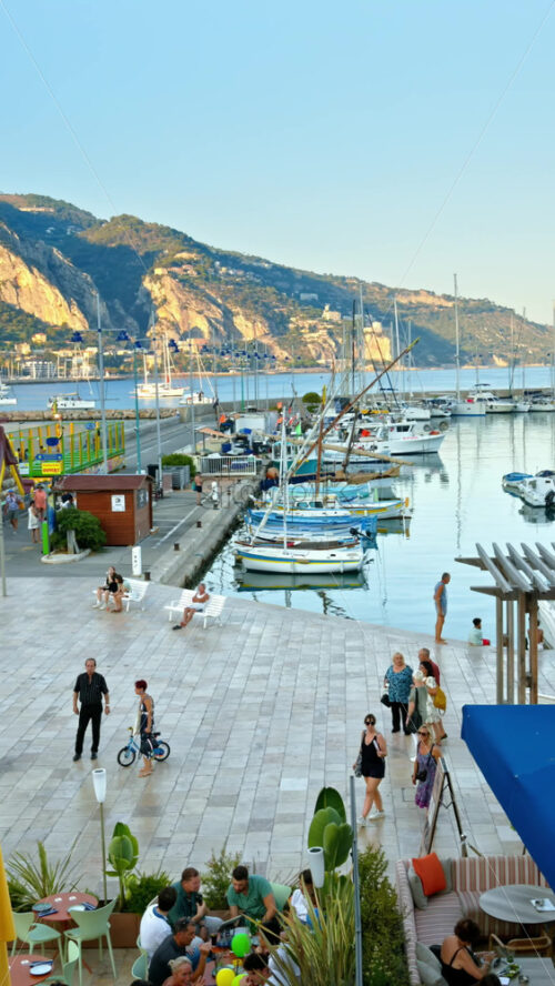 Video - View of the Port de Menton in the French Riviera with people walking near it. Vertical