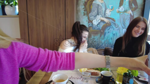 Video - Three women looking at pictures at a phone at a restaurant