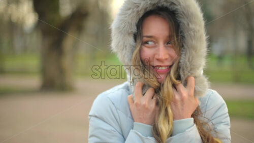 Video - Woman in a grey puffer jacket in a park
