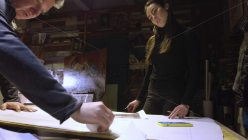 Video - Man helping a woman sketching on a canvas at an art gallery workshop