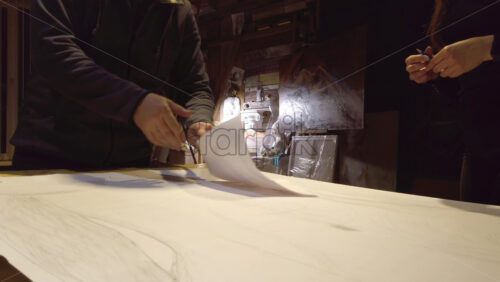 Video - Man supervising a woman sketching on a canvas at an art gallery workshop