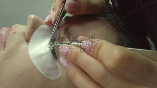 Video - Close up of a woman doing lash extensions to another woman