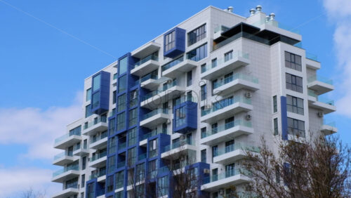 Video - The facade of a blue and white building with the sky on the background