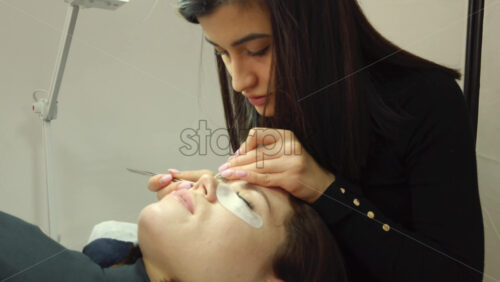 Video - Close up of a woman doing lash extensions to another woman
