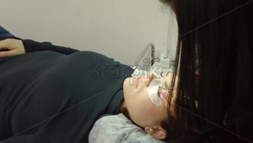 Video - Close up of a woman doing lash extensions to another woman