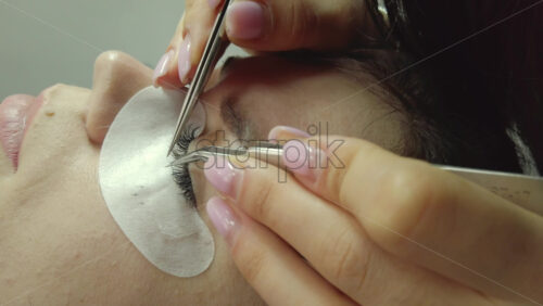 Video - Close up of a woman doing lash extensions to another woman