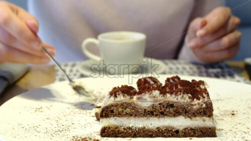 Video - Close up of a woman eating tiramisu at a cafe