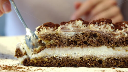 Video - Close up of a woman eating tiramisu at a cafe