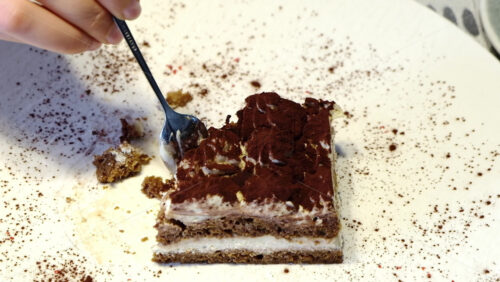 Video - Close up of a woman eating tiramisu at a cafe