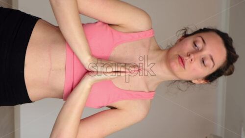 Video - Woman in sportswear doing yoga at home. Vertical