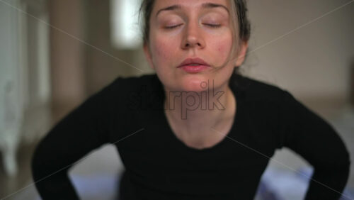 Video - Close up of a woman in sportswear stretching at home