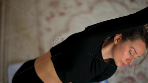 Video - Close up of a woman in sportswear stretching at home