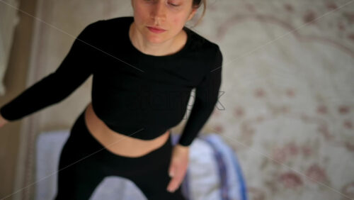 Video - Close up of a woman in sportswear stretching at home