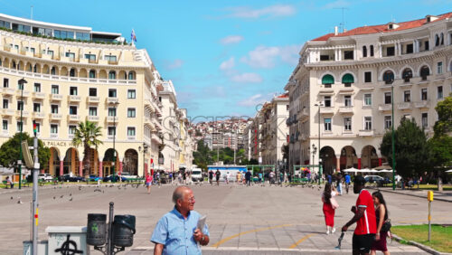 Video - THESSALONIKI, GREECE - SEPTEMBER 21, 2020: A front view of a greek hotel. Lots of people walking around the buildings