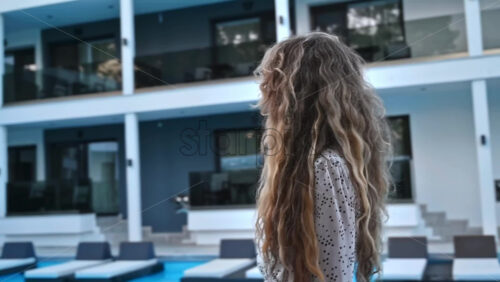 Video - A woman making a happy memory about her vacation, by the pool. Slow motion