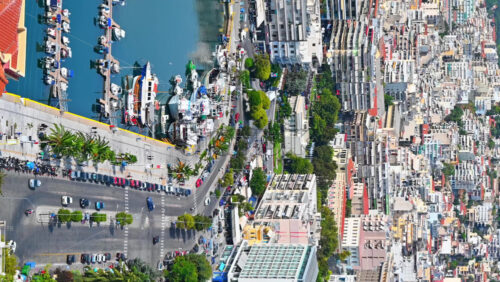 Video - KAVALA, GREECE - SEPTEMBER 23, 2020: Aerial view of the city. Rows of residential buildings, Aegean sea port with moored yachts, roads with people and cars