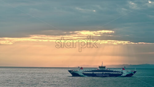 Video - THASOS, GREECE - SEPTEMBER 23, 2020: View of sunset from the water of Aegean sea. Moving ferryboat. Orange sky, cloudy weather, godrays