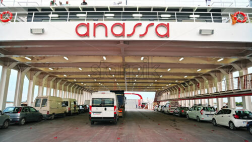 Video - THASSOS, GREECE - SEPTEMBER 23, 2020: Moored ferryboats in the port with trucks, minibuses and cars parked inside, opened gangplank, people on the second deck
