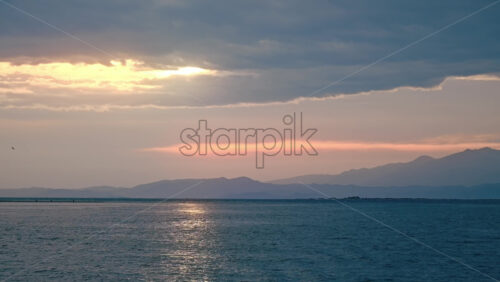 Video - View of sunset in Greece from the water of Aegean sea. Orange sky, cloudy weather