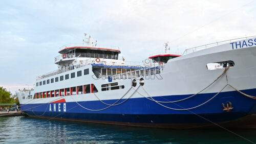 Video - THASSOS, GREECE - SEPTEMBER 23, 2020: Moored ferryboats in the port with red and blue exteriors, opened. Cloudy weather