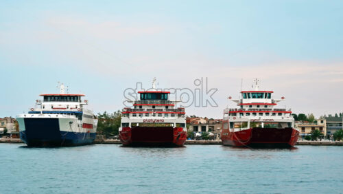 Video - THASSOS, GREECE - SEPTEMBER 23, 2020: Moored ferryboats in the port with red and blue exteriors, opened. Cloudy weather