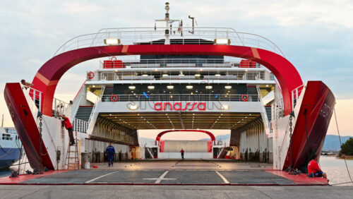 Video - THASSOS, GREECE - SEPTEMBER 23, 2020: Moored ferryboat in the port with red exterior, opened gangplank, people are working