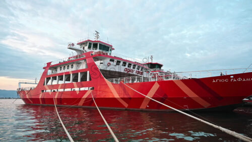 Video - THASSOS, GREECE - SEPTEMBER 23, 2020: Moored ferryboat in the port with red exterior, opened gangplank