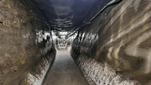 Video - Turda, Romania - July 20, 2025: A narrow, illuminated tunnel inside the Turda Salt Mine