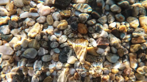 Video - Rocky bottom of the Aegean sea visible through the clear water, refraction of light. Greece