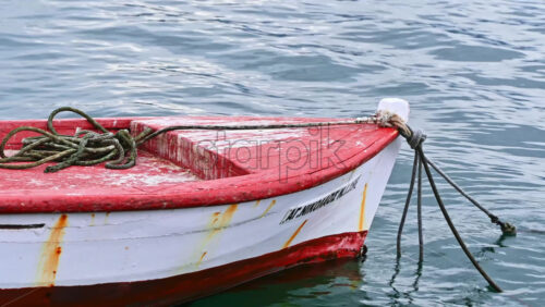 Video - STAVROS, GREECE - SEPTEMBER 26, 2020: Moored red and white boat made of metal and wood near the shore of the Aegean sea