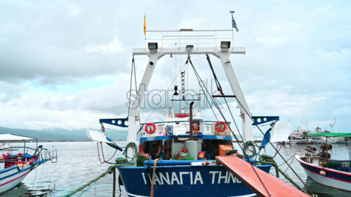 Video - STAVROS, GREECE - SEPTEMBER 26, 2020: Moored blue and white boat with lowered bridge, made of metal near the shore of the Aegean sea
