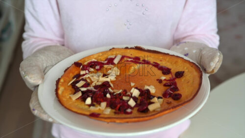 Video - Hands holding a pancake with dried fruits an nuts on a white plate