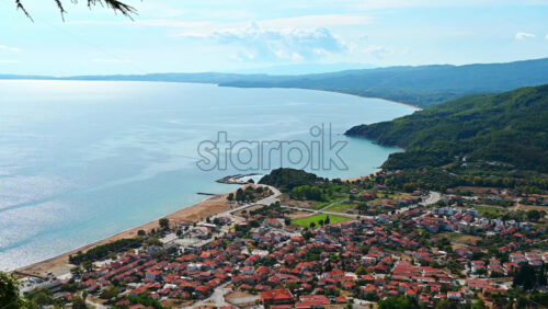 Video - Panorama view of Stratonion, multiple buildings on Aegean sea coast, hills covered with lush greenery, Greece