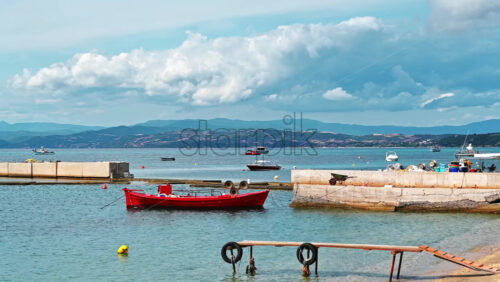 Video - Moored boats on Aegean sea coast, two piers, hill on the background, Ouranoupolis, Greece