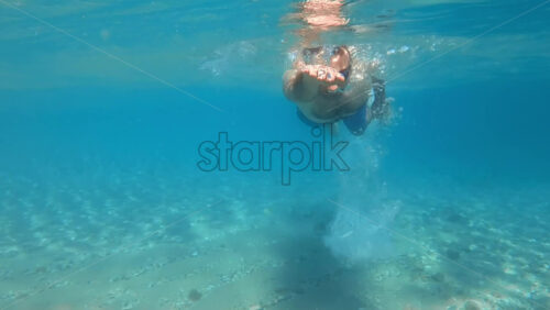Video - Man in swimming goggles under the water, Aegean sea. Slow motion, underwater shooting. Greece