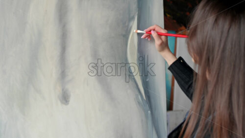 Video - Woman painter wearing black clothes painting woman model at a workshop