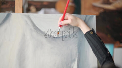 Video - Woman painter wearing black clothes painting woman model at a workshop