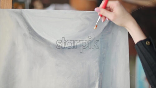 Video - Woman painter wearing black clothes painting woman model at a workshop