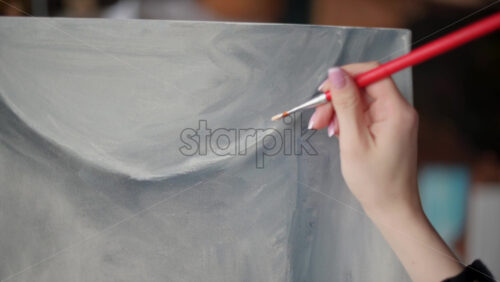 Video - Woman painter wearing black clothes painting woman model at a workshop