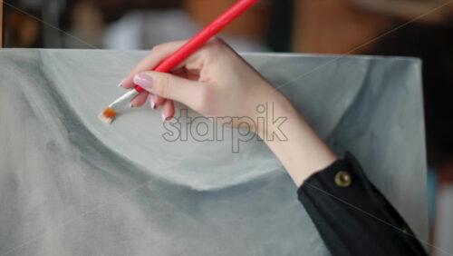 Video - Woman painter wearing black clothes painting woman model at a workshop