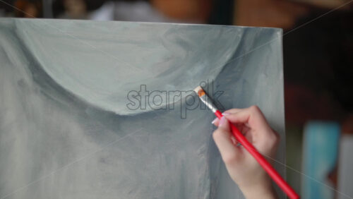 Video - Woman painter wearing black clothes painting woman model at a workshop